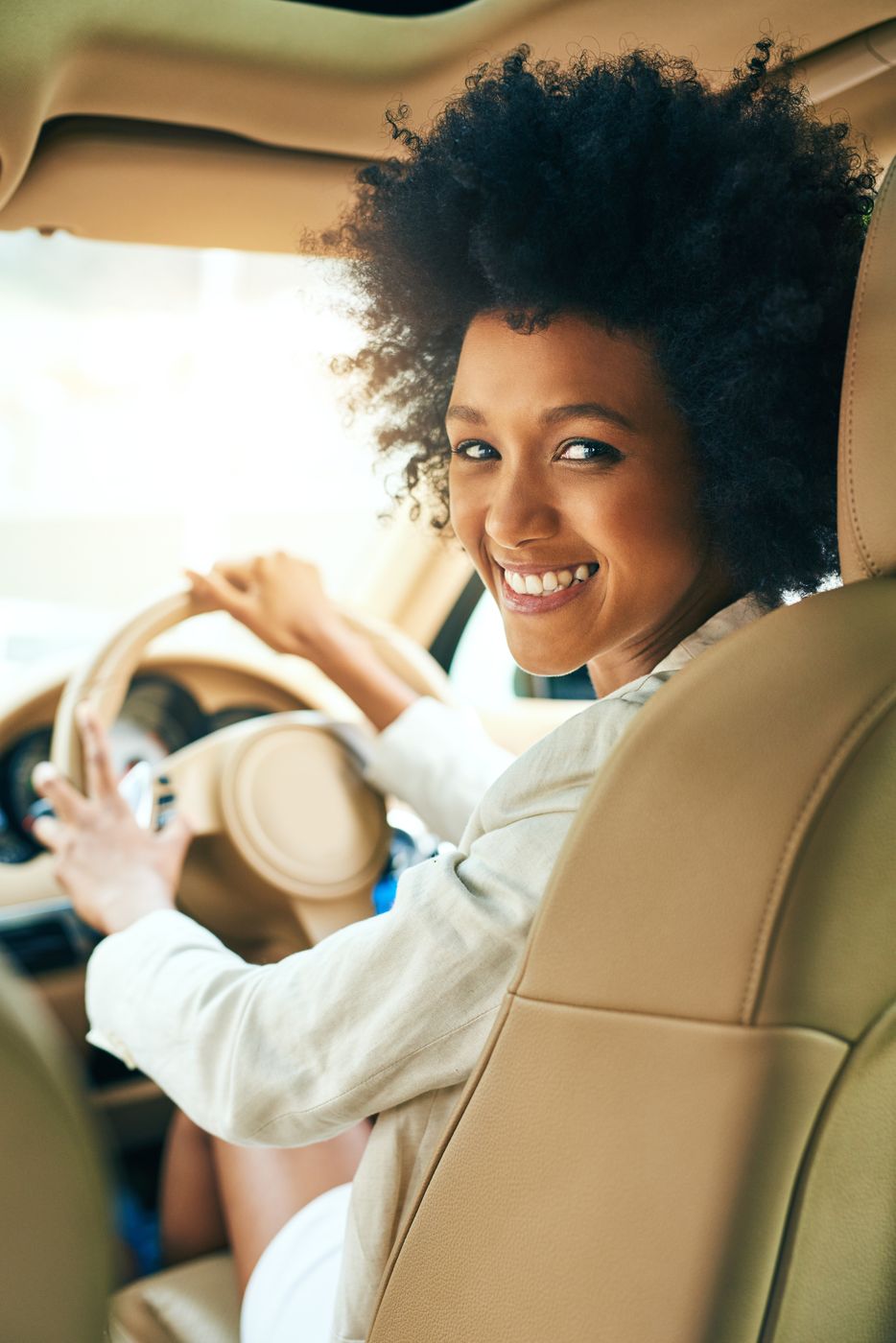Aluna sorrindo ao volante do carro de aula