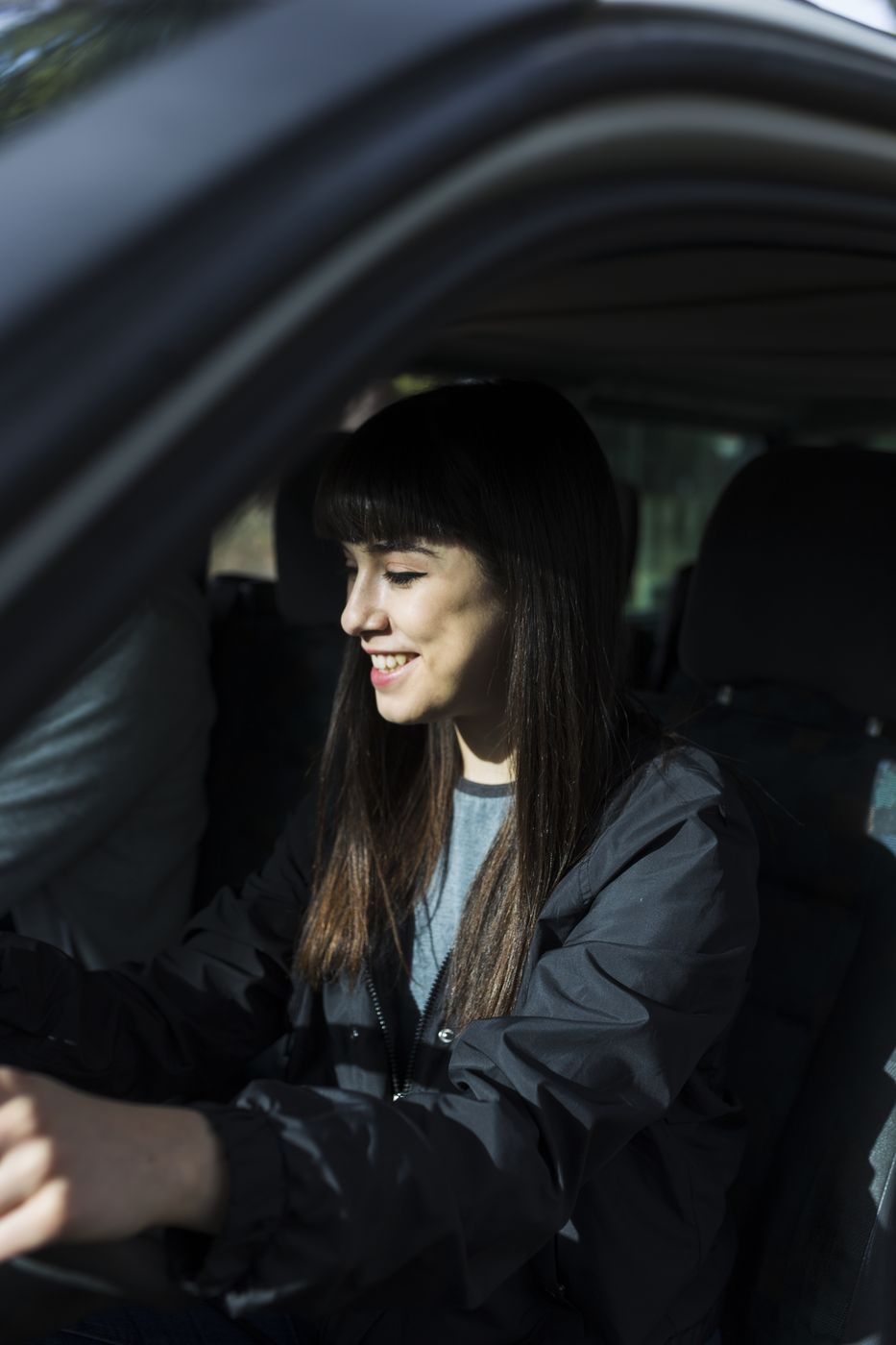Mãos de aluna no volante durante a aula